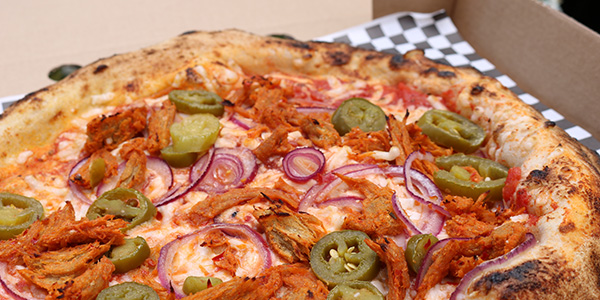 Seitan spicy mock-chicken pizza in pizza box